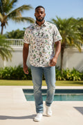 Lady Bear Resale white short sleeve linen shirt with a tropical beach scene print, featuring palm trees and figures.